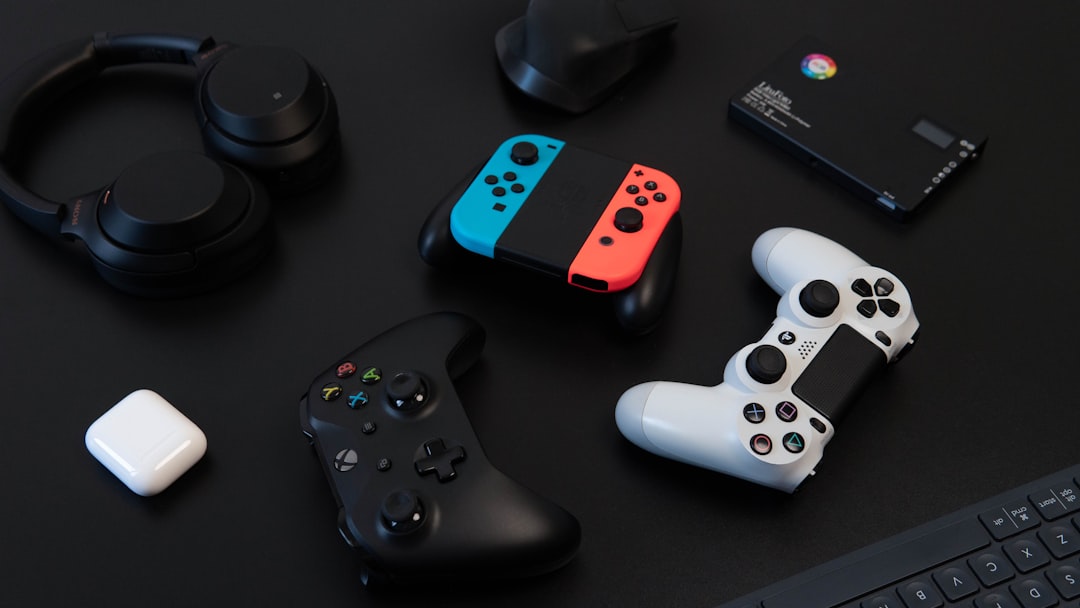 A collection of gaming accessories including a headset, keyboard, mouse, and controller on a desk setup.