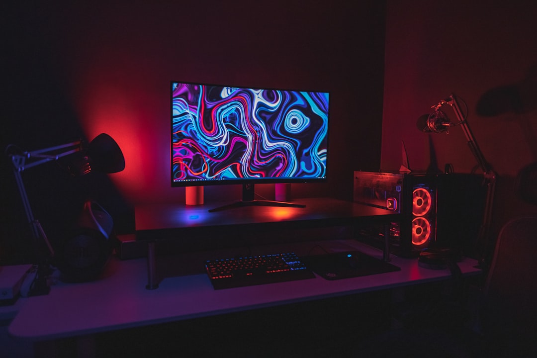 A compact gaming desk with a monitor, keyboard, and gaming accessories in a small room.